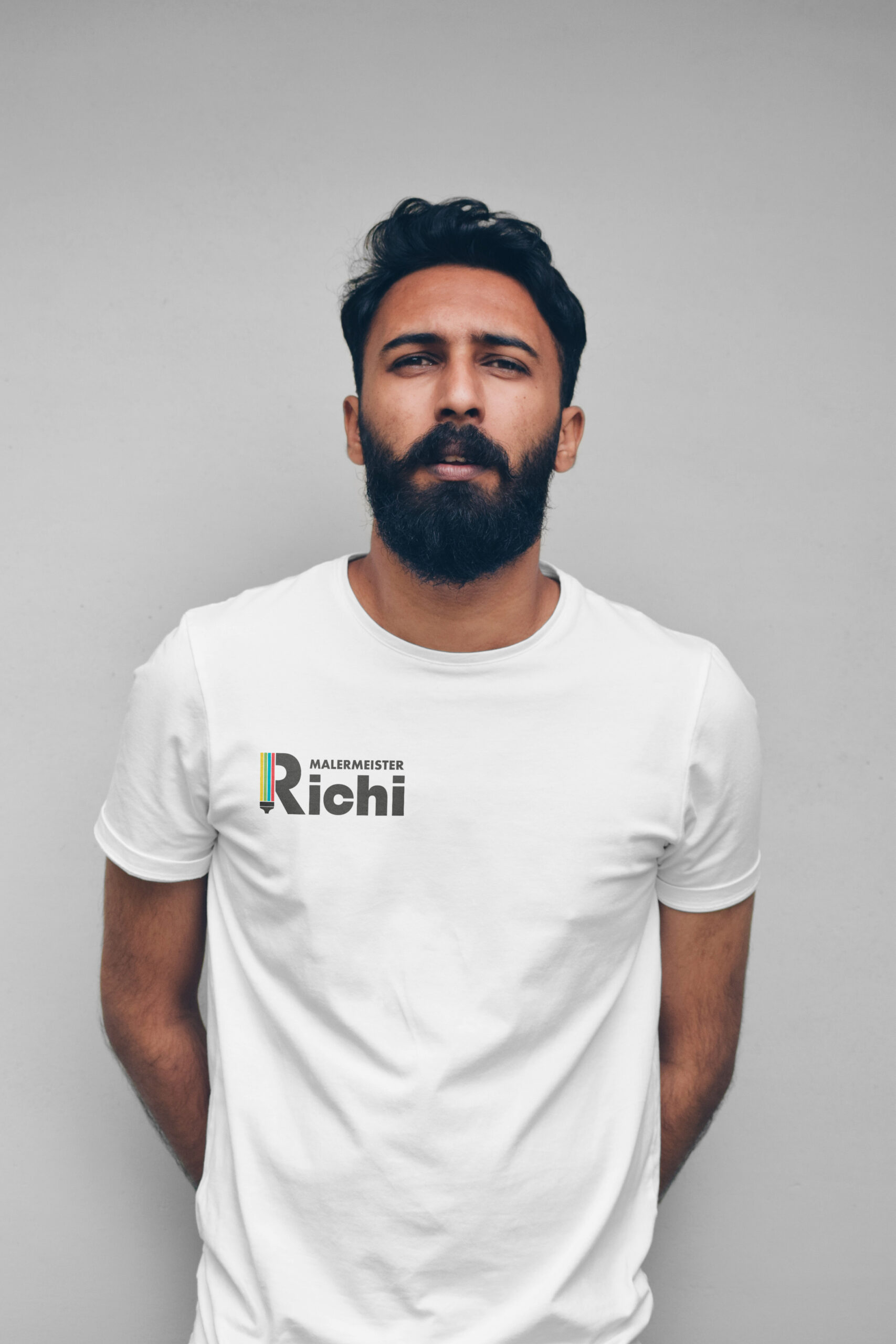 Mann mit weissem T-Shirt mit dem Logo von Malermeister Richi